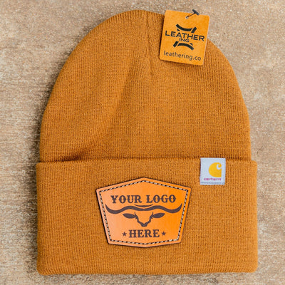 Yellow beanie with leather patch on a beige background