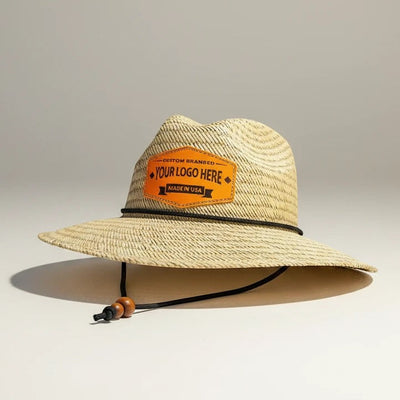 Leathering natural straw hat with a black cord and wooden beads, featuring a custom orange leather patch with 'YOUR LOGO HERE'.