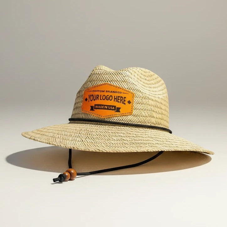 Leathering natural straw hat with a black cord and wooden beads, featuring a custom orange leather patch with 'YOUR LOGO HERE'.
